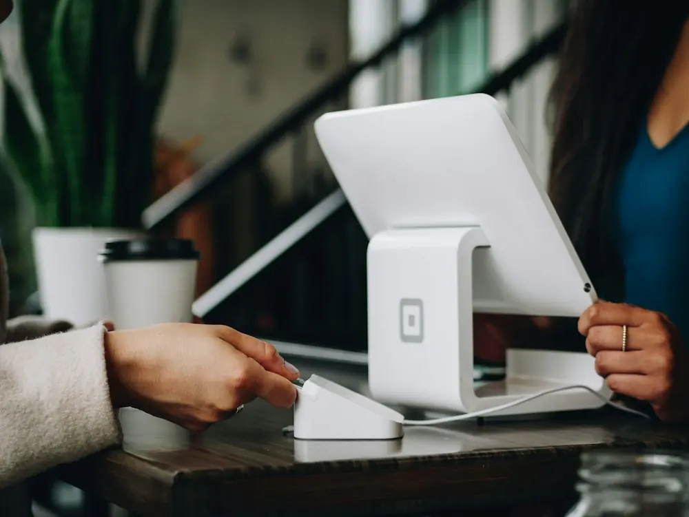 A business owner serving a customer at a payment counter