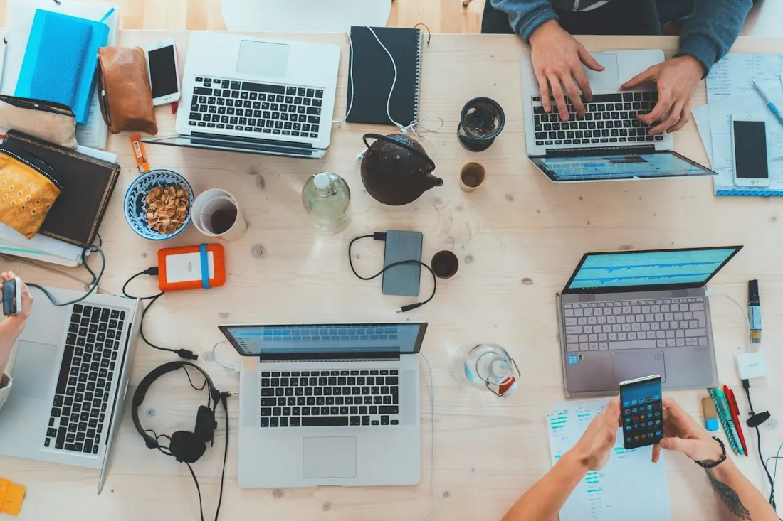 Marketing professionals collaborating on laptops at a shared desk